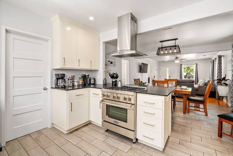 Fully-stocked kitchen with high-end cookware and stainless steel appliances.