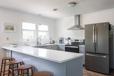 Top Level Fully Equipped Kitchen with Refrigerator, Oven, Microwave, Coffee Maker, and Toaster plus a Breakfast Bar with Seating and Windows that bring in Plenty of Natural Light