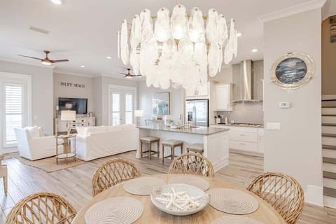 A chic dining area with a statement chandelier, coastal-themed décor, and seating for memorable meals with family and friends.