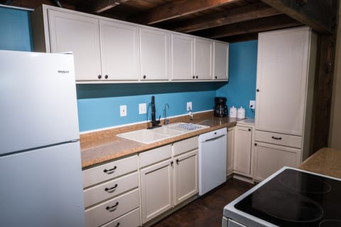 Kitchen with dishes, cookware, and appliances. 