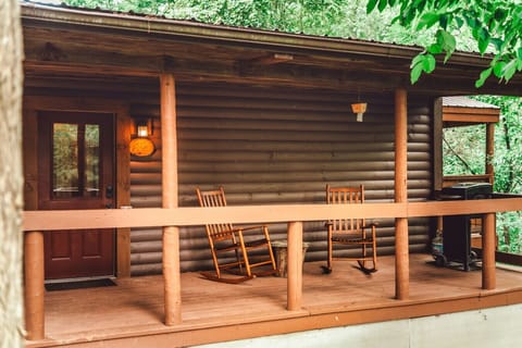 Front porch rocking chairs and forest backdrop welcome couples into a peaceful Hocking Hills cabin escape