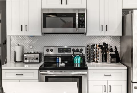 Well stocked kitchen with quartz countertops.  Spice rack, oil and cooking essentials .