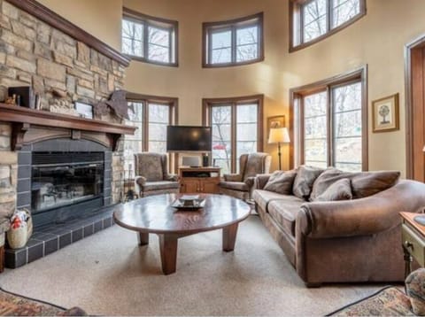 Living room with cathedral ceiling, wood burning fireplace and ample seating