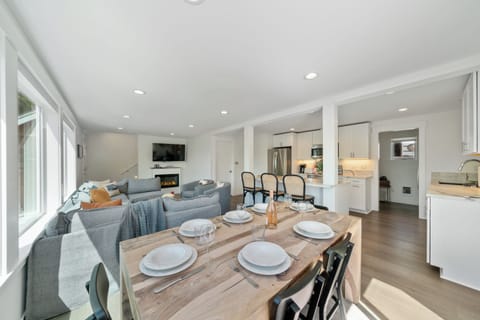 Dining room open to Living room with electric fireplace, Streaming TV, and kitchen with Bar seating.