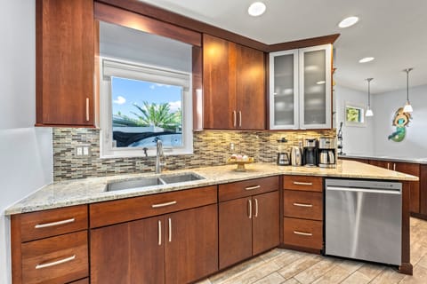 The double sink frames a sun-drenched view, letting sparkling light dance across the counters while you prep fresh coastal meals.