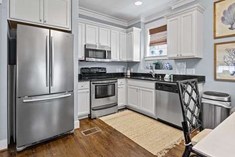 You'll love cooking in this bright, fully-equipped kitchen with stainless steel appliances and elegant white cabinetry.