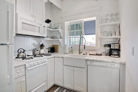 Kitchen area with gas stove/oven.  Lots of dishes, pots and pans.