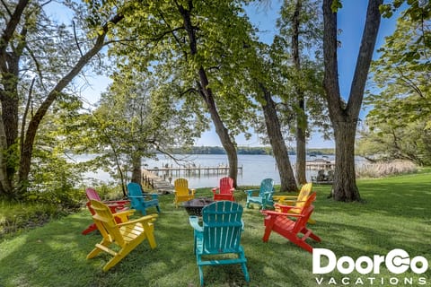 Amazing waterfront firepit with colorful Adirondack chairs!