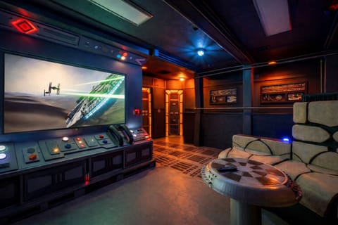 Immersive sci‑fi theater lounge with console, big screen & mood lighting