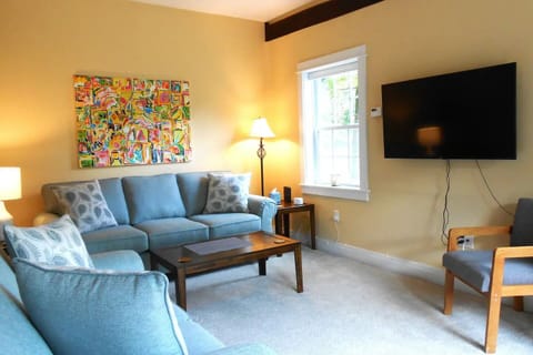 Living room with sofa and loveseat, the 50" TV can be adjusted for easy viewing