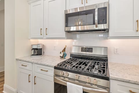 The kitchen is equipped with a gas range and oven with a built-in microwave.