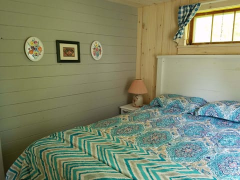 Main bedroom features a queen bed and windows that let you head the brook