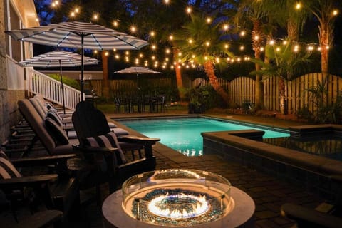 Pool at night with string lights and fire pit