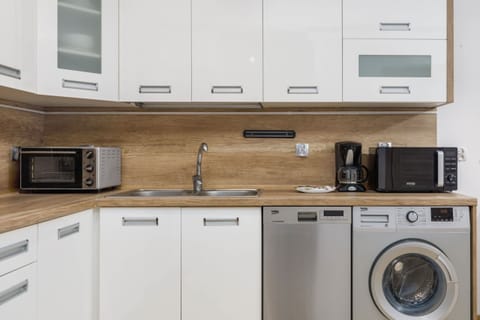 Another angle of the kitchen showcasing ample storage, modern design, and a full-sized fridge.
