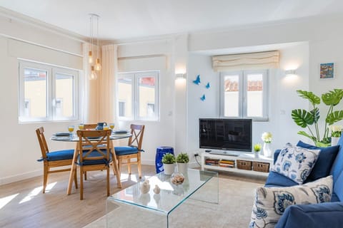 Modern and comfortable living area with a versatile sofa bed, a sleek TV for entertainment, refreshing air conditioning, and a dining table #modern #entertainment #portugal #pt #cascais