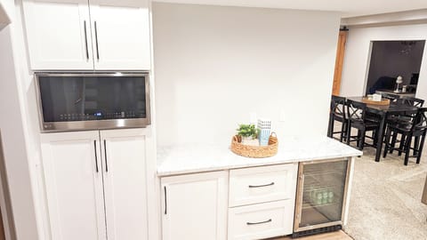 Basement bar space with beverage fridge and microwave. 