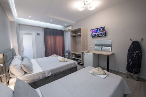 Deluxe Triple Room | Desk, bed sheets