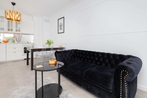 A close-up of the elegant black tufted sofa with metallic accents, adding a touch of sophistication to the living room.
