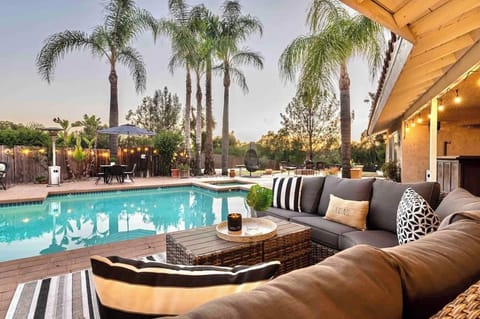 Your private resort right in your backyard, featuring calm pool waters, plush outdoor seating, and the gentle glow of warm string lights. Surrounded by palm trees, it’s the perfect escape for relaxation, making your stay extra special.