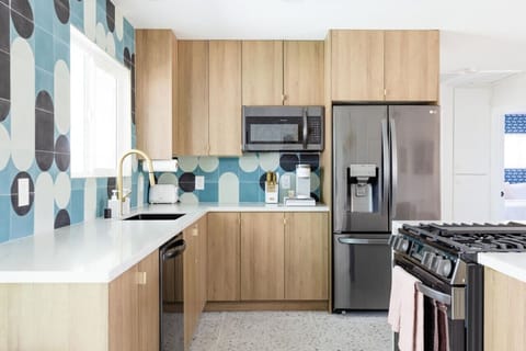 Modern kitchen w/ warm wood cabinetry, stainless appliances & clean lines for effortless meals.