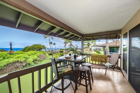 Spacious covered lanai with a four-seat dining set, perfect for enjoying meals while overlooking lush tropical gardens and serene resort views.
