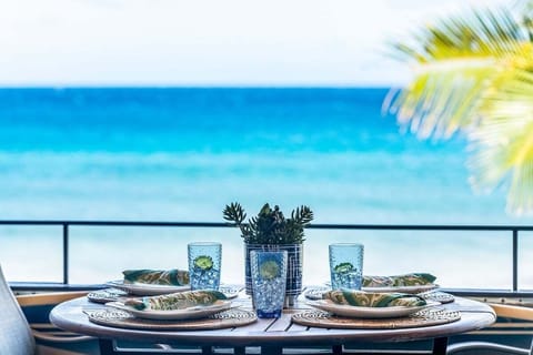 Oceanfront lanai dining for four with sunset views over turquoise Maui waters.