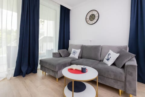 The spacious living room features a comfortable sofa bed and a flat-screen television.