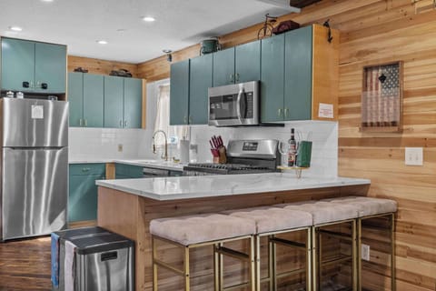 A kitchen made for gathering—featuring stainless steel appliances and a breakfast bar with stool seating. Perfect for cooking and connecting! 🍽️✨