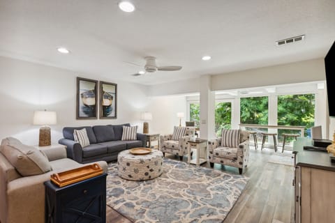 Bright and Cheerful Living Area with Sofa and Loveseat Centered Around a Flat Screen Smart TV