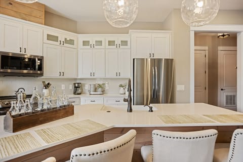 Modern kitchen w/ stainless appliances, granite island, dining for four.