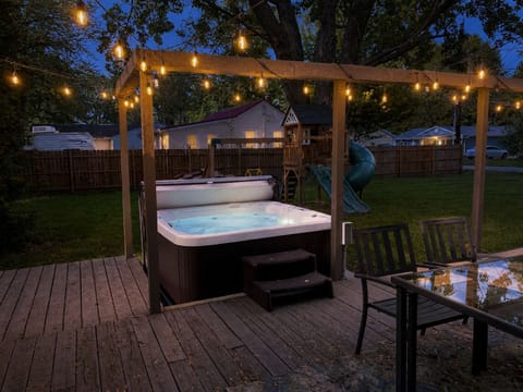 Unwind in the private hot tub under twinkling string lights ✨. Perfect for evening soaks, surrounded by a spacious deck, dining area, and fenced-in yard.