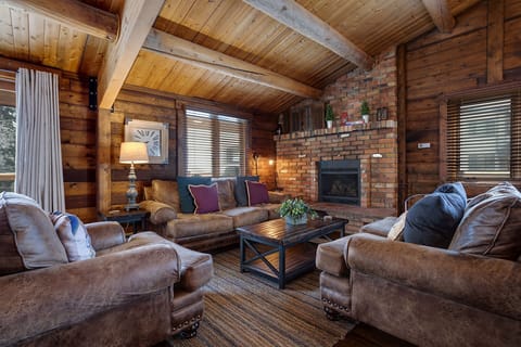 Sink into plush leather seating by your crackling fireplace, where rustic wood beams and brick create the perfect cozy retreat.