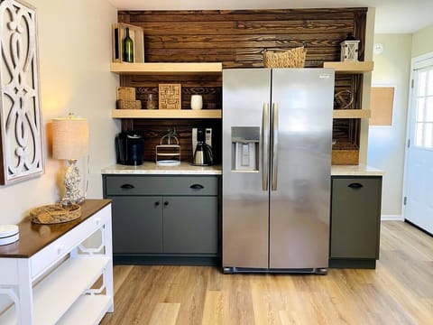 A brand new refrigerator with in-door ice and water dispenser. The door to the left goes out to the back deck. Coffee options include both a keurig and a 12-cup drip coffee pot.