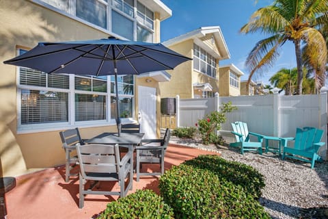 Tropical outdoor patio w/ dining table & umbrella, perfect for relaxed meals in the sunshine.