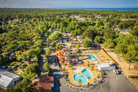 Take in the beautiful aerial view of Riez à la Vie, where lush greenery meets the sparkling coast, making it an idyllic getaway for families seeking relaxation and fun.