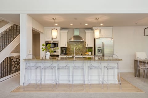 Fully-equipped kitchen with modern appliances and barstool seating.