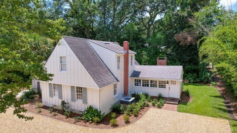 Aerial view of property with gray roof and trees