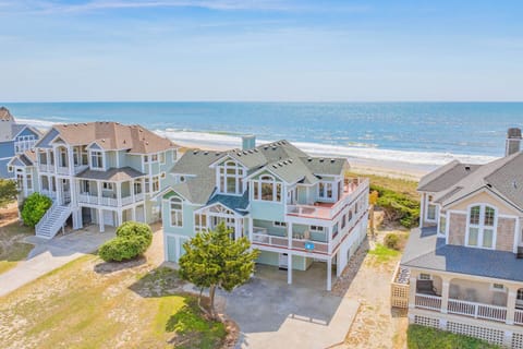 Aerial view of a beachfront vacation rental community, with the property situated just steps from the sandy shoreline and sparkling ocean waves.