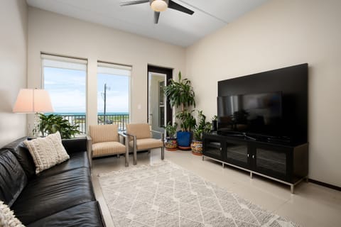 Relax in the comfortable living room featuring a large TV and easy access to the private balcony.