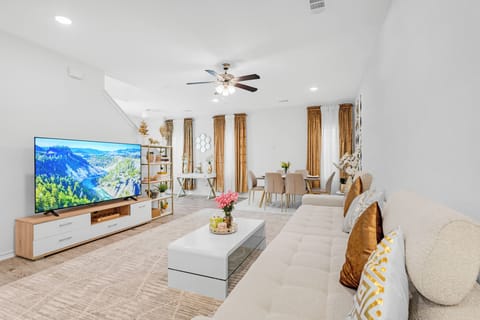 Living room with oversized couch and 75 inch tv