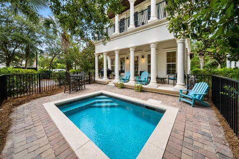 Your private oasis awaits with sparkling pool, elegant columns, and comfortable seating surrounded by lush tropical landscaping.