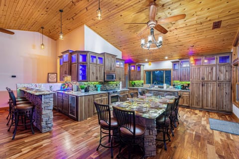 Room for everyone to gather! Seats for 4 at the bar, 10 at the indoor dining table, and 10 more at the outdoor table on the back deck—just a few steps away