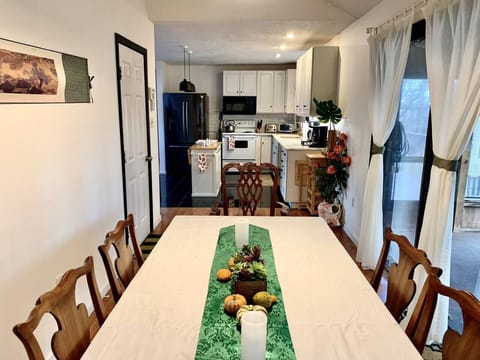 A dining room perfect for setting up a wonderful home cooked meal. Extra seating can be available using chairs from the outside porch area. 