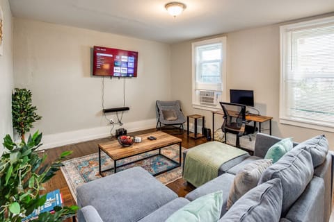 Cozy living room in Rochester with sectional sofa, Roku TV & desk nook—modern retreat blending entertainment and workspace.