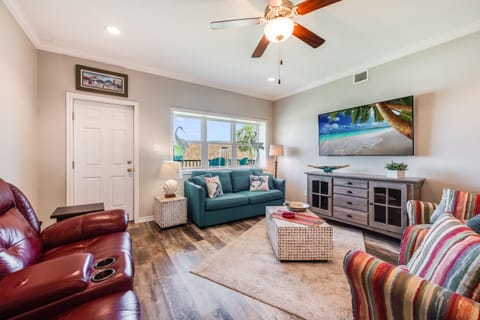 Unwind in your comfortable living room with leather recliners, cozy seating, and tropical vibes from the large TV.