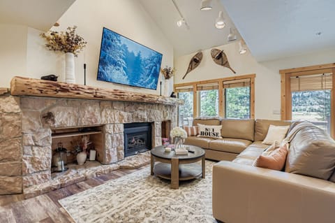 Relax by the stone fireplace in this cozy living room. Ample seating and a large TV make it the perfect spot to unwind after a day exploring Park City.
