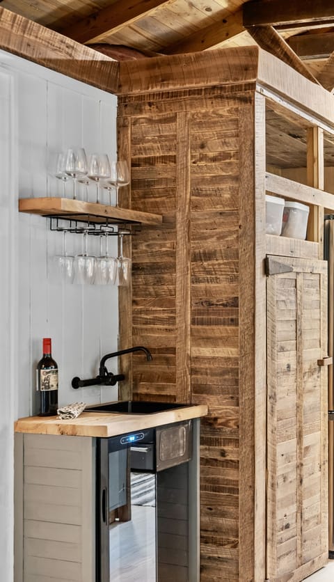 Wet bar, stocked with wine glasses and a beverage cooler.