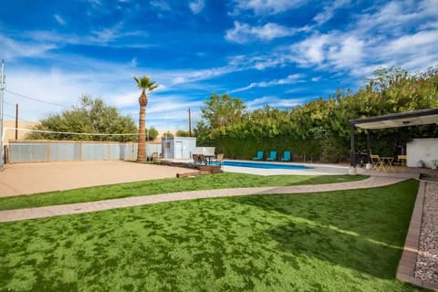 Expansive backyard with lush grass, lounging areas, and a covered patio for outdoor relaxation and gatherings.