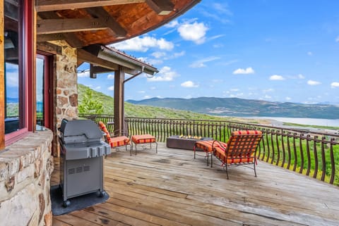 - Outdoor deck with fire pit seating and lounge chairs  
- Relax with panoramic mountain and lake views  
- Airbnb stay with outdoor BBQ grill and patio