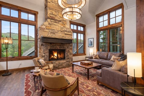 Unwind in the inviting, vaulted living room, featuring a striking stone fireplace and comfortable seating.